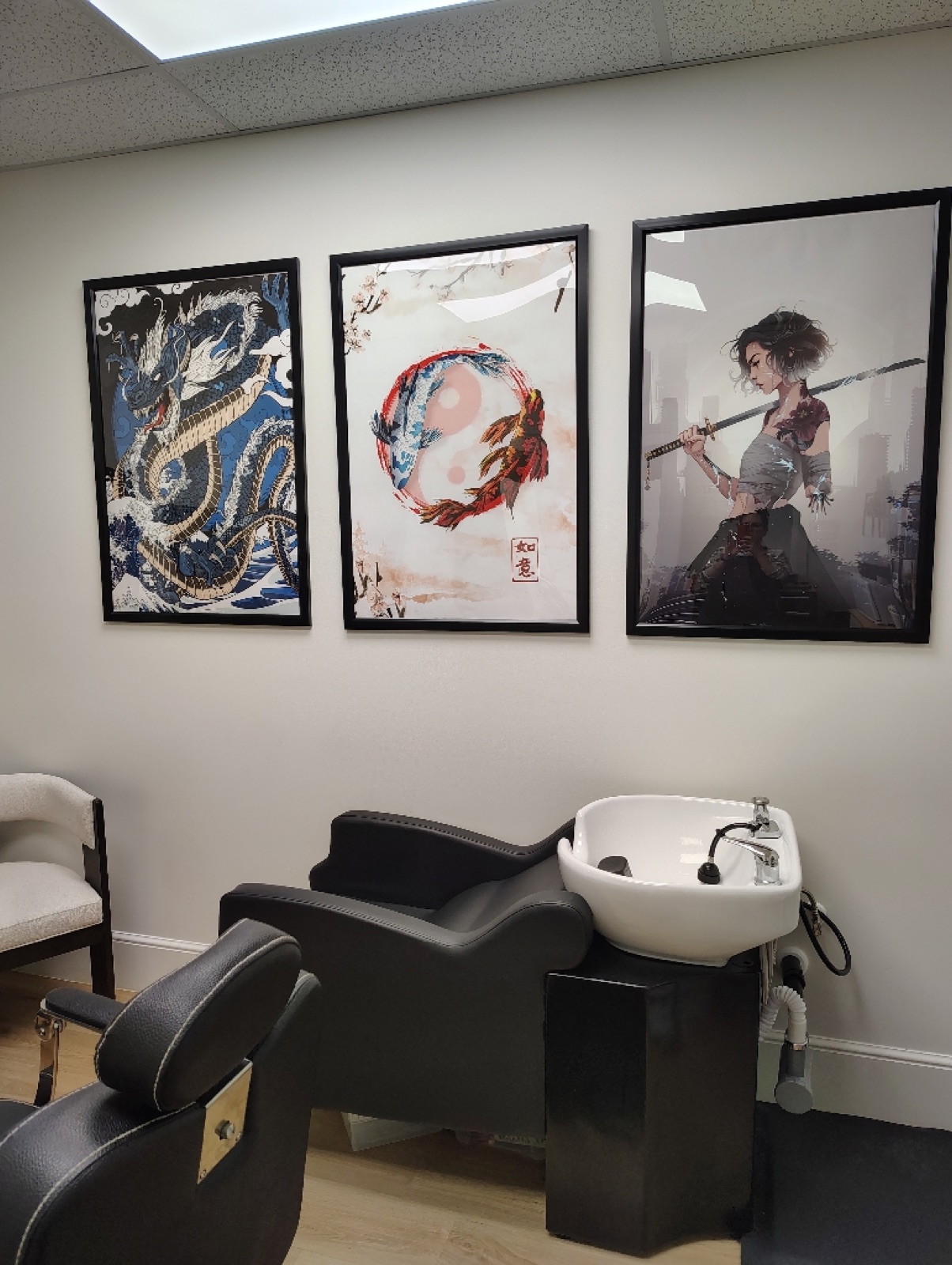 The barber chair at Nielson's Barbering & Beyond, with framed art and a large mirror
